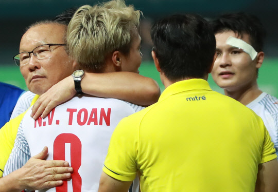 27일 오후(현지시간)인도네시아 자와바랏주 브카시의 패트리엇 스타디움에서 열린 2018 자카르타-팔렘방 아시안게임(AG) 남자 축구 8강 베트남과 시리아의 경기. 연장 승부 끝에 1-0으로 승리한 베트남 박항서 감독이 이날 연장 후반 결승골을 넣은 응우옌 반 토안과 포옹하고 있다.   연합뉴스